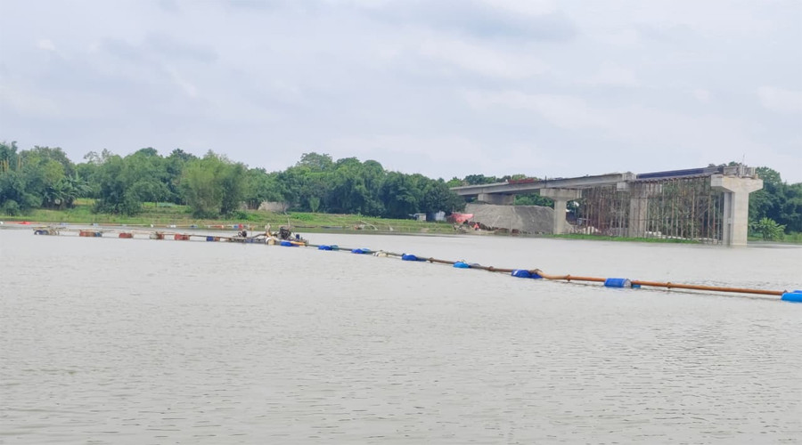 ভোলাহাটে মহানন্দা নদীর উপর সেতু নির্মাণাধীন এর পাশদিয়ে বালু উত্তোলনের দৃশ্য। ছবিতে পাশে-নির্মানাধীন সেতুর কিছুটা অংশ দেখা যাচ্ছে। ছবি : এম. এস. আই শরীফ